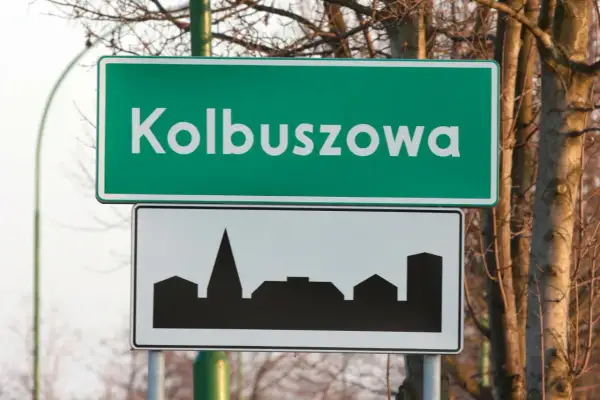 Znak drogowy z napisem "Kolbuszowa" i sylwetką miasta. D42.