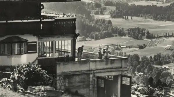 Blick vom Berghof Obersalzberg auf das malerische Tal. Menschen genießen die Aussicht von der Terrasse.