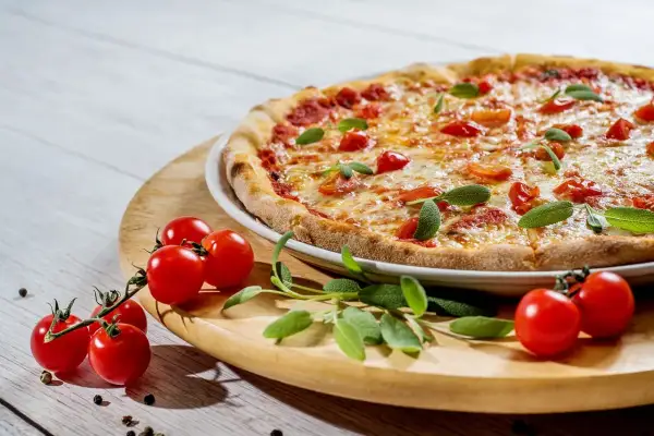 Szukasz miejsca, gdzie dobrze i tanio zjeść w Mikołajkach? Ta pyszna pizza z pomidorkami i bazylią to idealna propozycja!
