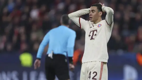 Jamal Musiala, piłkarz Bayernu, z rękami na głowie, wyraża frustrację na boisku.