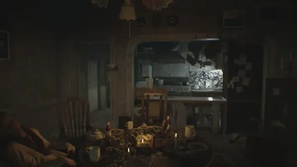 Mroczna jadalnia z obficie zastawionym stołem i śpiącym mężczyzną. W tle kuchnia, jak z poradnika Resident Evil 7.