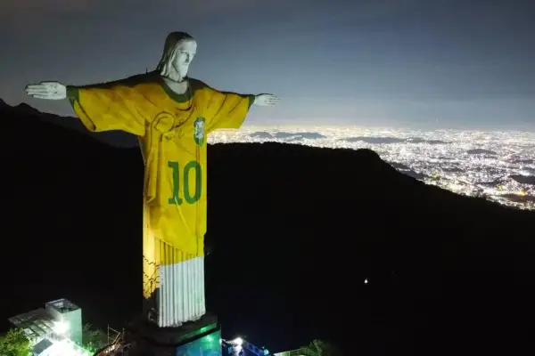 Rio de Janeiro Jezus w koszulce z numerem 10, symbolizujący dumę Brazylii, góruje nad nocnym miastem.