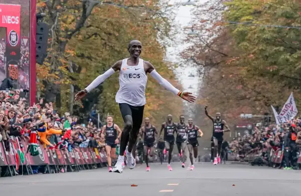 Eliud Kipchoge przekracza linię mety, ustanawiając nowy maraton rekord świata. Tłumy wiwatują, widząc historyczny bieg.