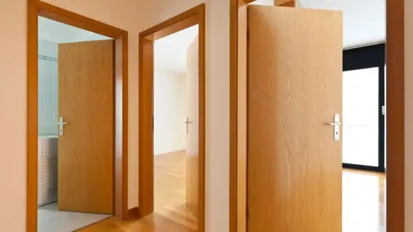 Pasillos con puertas de madera clara. Aprende como limpiar puertas de contrachapado para mantenerlas así de relucientes.