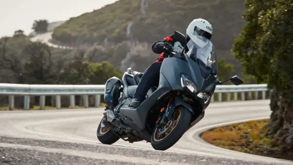 Motociclista en TMAX, disfrutando de la velocidad máxima en una carretera sinuosa.