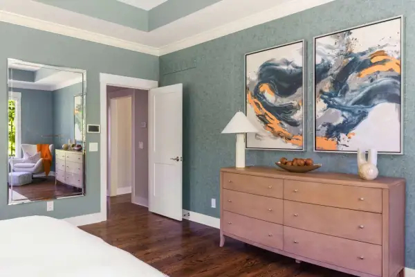 A tall dresser with a lamp, fruit bowl, and vase offers elegant tall dresser decor ideas.