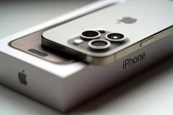 Srebrny iPhone 15 na pudełku Apple. Zbliżenie na aparat i logo. Idealne iphone 15 wymiary.