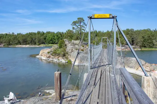Hängbro över vatten med skogklädda öar. Perfekt för en utflykt Stockholm.