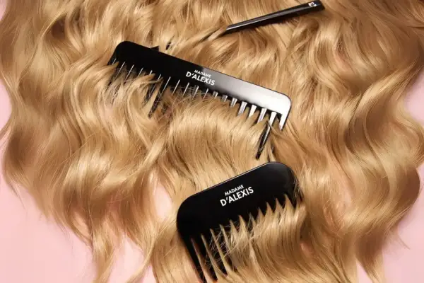 Trois peignes noirs de Madame D'Alexis reposent sur des cheveux blonds ondulés et élastiques.