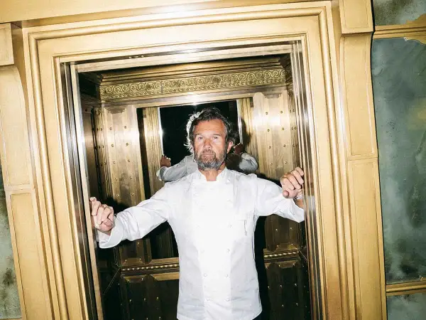 Lo chef Cracco, con la sua giacca bianca, in un ascensore dorato. Quante stelle Michelin ha Cracco?