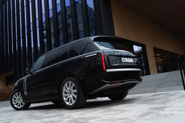 Elegancki czarny Range Rover Autobiography lśni na tle nowoczesnej architektury.