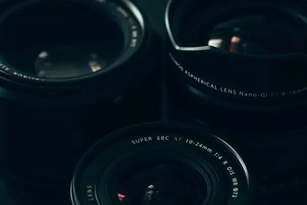 Three Fujifilm lenses, including the XF 10-24mm, are arranged for a street photography shoot.