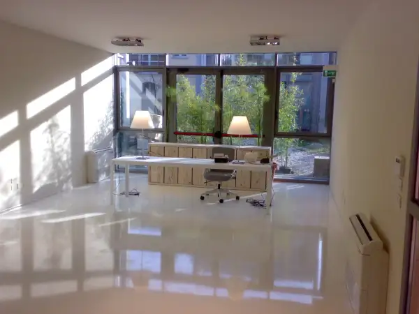 Ufficio moderno con pavimento in resina lucida, ideale per chi cerca un design minimalista e vuole conoscere i prezzi pavimenti in resina.