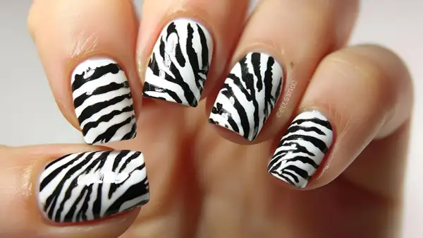 Paznokcie motyw zwierzęcy w stylu zebra. Czarne pasy na białym tle tworzą dziki wzór.
