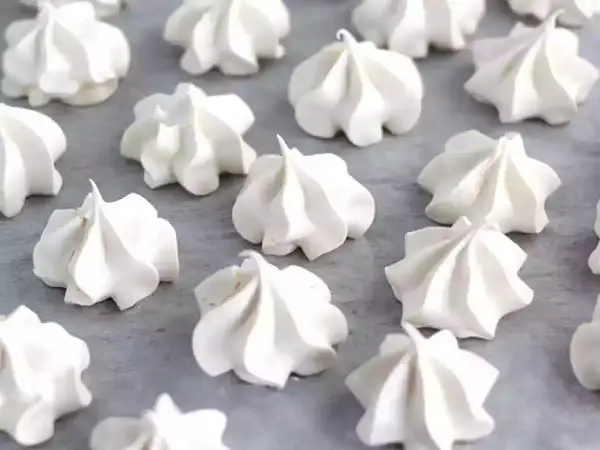 Une belle **recette meringue** : des petits nuages blancs et aériens disposés sur une plaque.