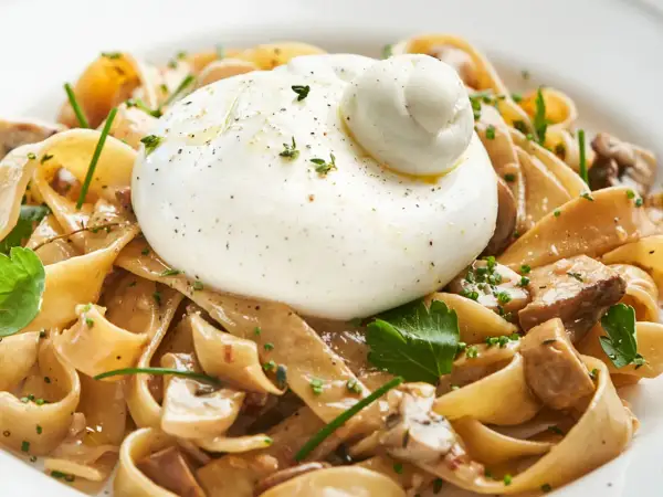 Pasta mit Pilzen und cremiger Burrata, ein köstliches italienisches Gericht.