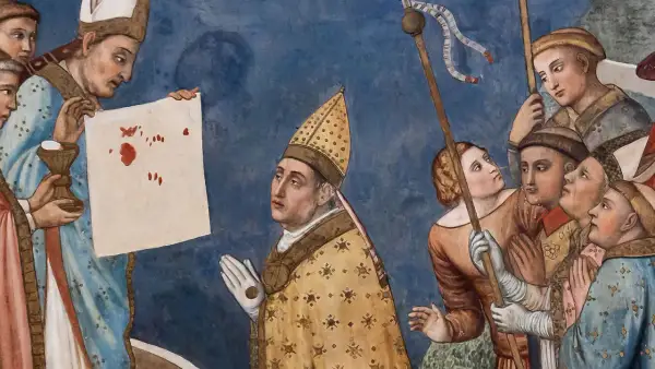 Opis sceny z Lanciano: kapłan ukazuje krwawe plamy na płótnie, symbolizujące cud eucharystyczny. Ludzie patrzą z podziwem.
