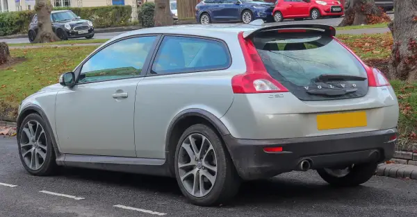 Srebrne Volvo C30 z charakterystycznym tyłem i spoilerem, zaparkowane na ulicy.