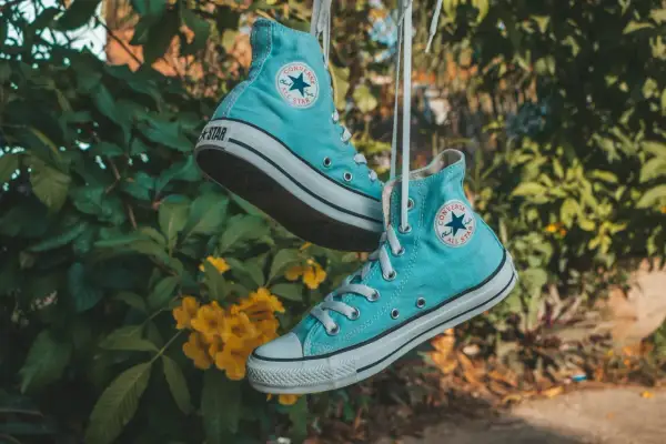 Scarpe All Star azzurre appese, pronte per essere lavate in lavatrice.