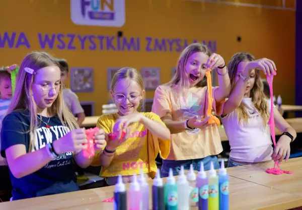 Dzieci tworzą slime, świetne atrakcje na Dzień Dziecka. Radość i kreatywność w kolorowym świecie zabawy.