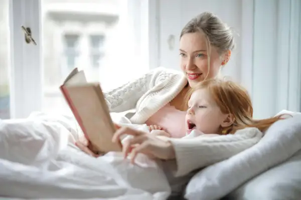 Madre e hija disfrutan de un momento acogedor con lectura en catalán para niños.