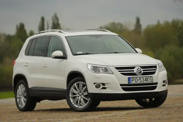 Biały Volkswagen Tiguan, gotowy do wymiany żarówki postojowej przód.