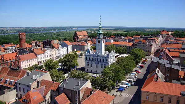Widok na rynek i ratusz w Gąsawie. W tle widać wieżę ceglaną i rzekę. To jedne z wielu gąsawskich atrakcji.