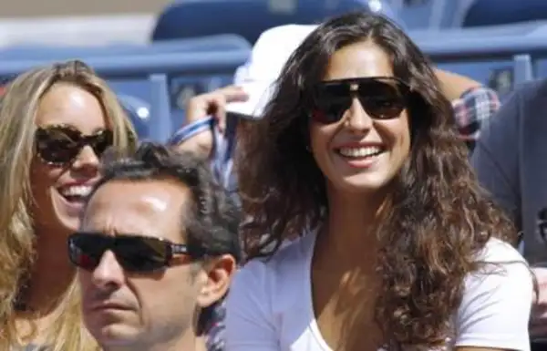 Xisca Perelló, con gafas de sol y una sonrisa radiante, disfruta de un evento deportivo junto a amigos.
