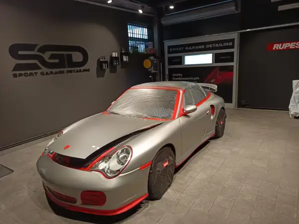 Auto sportiva pronta per il detailing. La carrozzeria è coperta per proteggerla durante il processo di come lucidare la macchina.