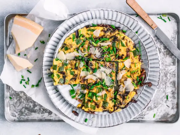 Herzhafte Frittata mit Paprika, Zwiebeln und Parmesan, garniert mit Schnittlauch. Perfekt für schnelle 15 Minuten Rezepte.