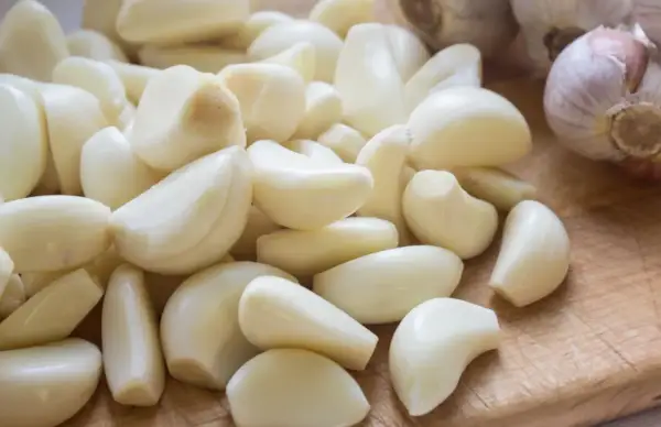 Stos czosnku, naturalny sposób na ziemiórki. Ząbki czosnku gotowe do użycia w ogrodzie.