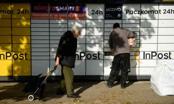 Osoby korzystają z paczkomatu InPost. Zastanawiasz się, ile prądu zużywa paczkomat? To urządzenie jest energooszczędne.