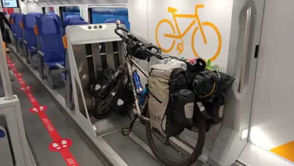 Rower w pociągu, gotowy na przygodę. Wygodne siedzenia i miejsce dla pasażerów z bagażem.