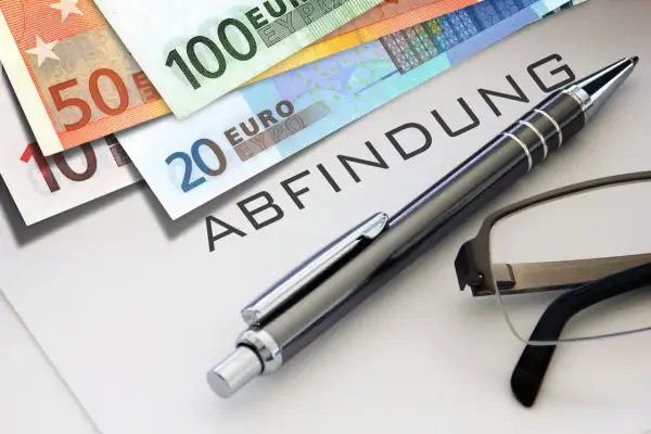 Euro-Scheine liegen auf einem Dokument mit dem Wort "ABFINDUNG". Ein Stift und eine Brille deuten auf eine bevorstehende Entscheidung oder Vereinbarung hin, vielleicht eine Abfindung nach 4 Jahren.