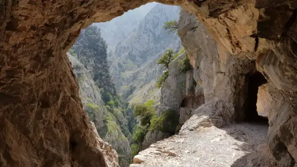 Vista desde una cueva de un desfiladero verde y rocoso, parte de la ruta de la reconquista.