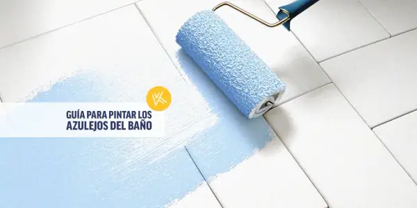 Rodillo azul pintando azulejos blancos, transformando un baño antiguo. Guía para pintar azulejos.