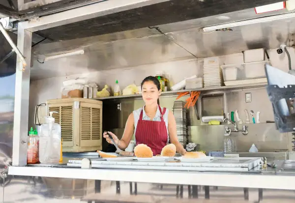 Donna prepara panini nel suo food truck, un sogno che sta per aprire.