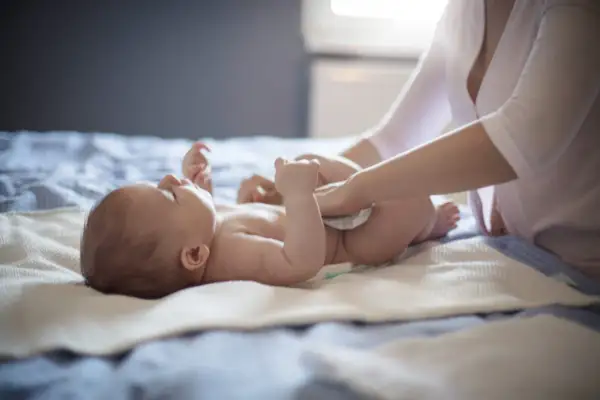 Mama zmienia pieluszkę niemowlaka, który ma biegunkę.