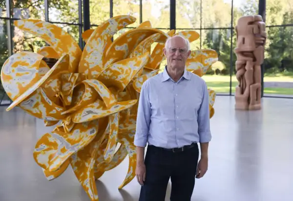 Tony Cragg in Wuppertal vor seiner gelben Skulptur. Im Hintergrund eine weitere Skulptur.