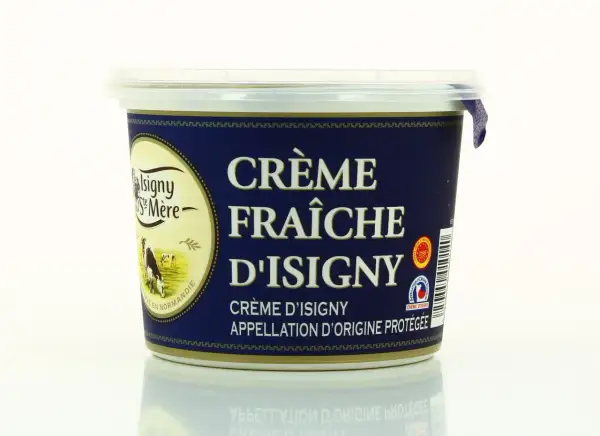 Un pot de crème fraîche d'Isigny, avec une vache dans un pré sur l'étiquette. La crème d'Isigny est une spécialité normande.