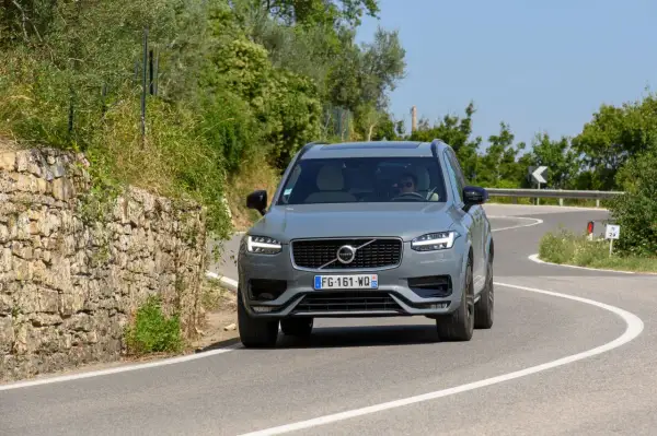 Szary Volvo XC90 2020 na krętej drodze wśród zieleni.