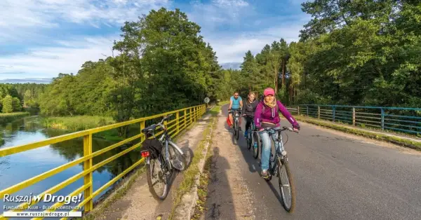 Rowerzyści przemierzają malownicze **Kociewie** wzdłuż rzeki.