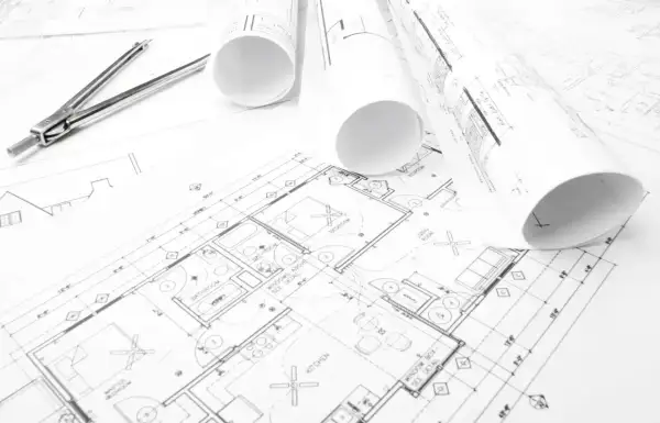 Plany budynków, gdzie szukać inspiracji i rozwiązań architektonicznych. Rysunki techniczne, cyrkiel i rolki z projektami.