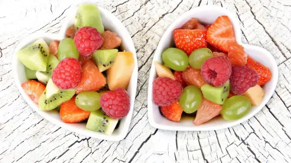 Dwa sercowate talerzyki wypełnione kolorowymi owocami: truskawkami, malinami, kiwi, winogronami i grejpfrutem. Idealne przekąski 0 kcal na zdrowy deser.