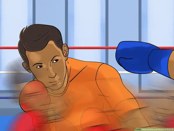 Boxer in orange shirt dodges a blue-gloved punch with a bob and weave motion in a boxing ring.