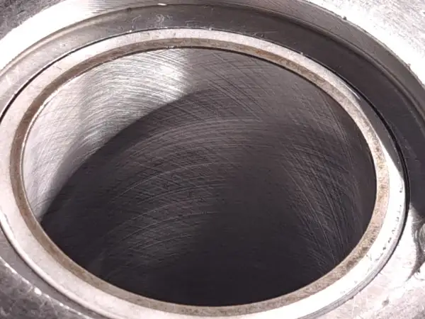 Metalowy cylinder z widocznymi śladami obróbki. Wnętrze, czyli big bore, jest ciemne i lekko błyszczące.