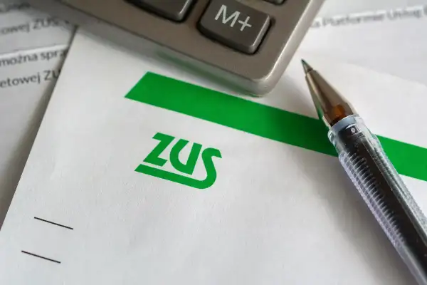 Długopis i kalkulator na dokumencie z logo ZUS.