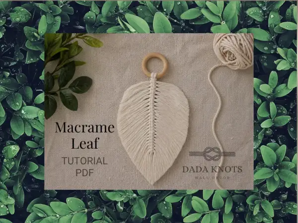 Décoration murale en macramé aux couleurs vives, avec des cordes torsadées formant des feuilles.