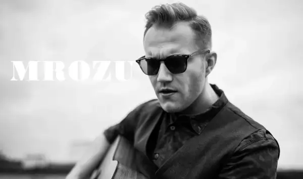 Mrozu w okularach przeciwsłonecznych gra na gitarze. Jego mrozu utwory poruszają serca słuchaczy.