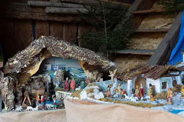 Dettaglio di presepi italiani con figure sacre, pastori e animali, ambientati in un paesaggio stilizzato.